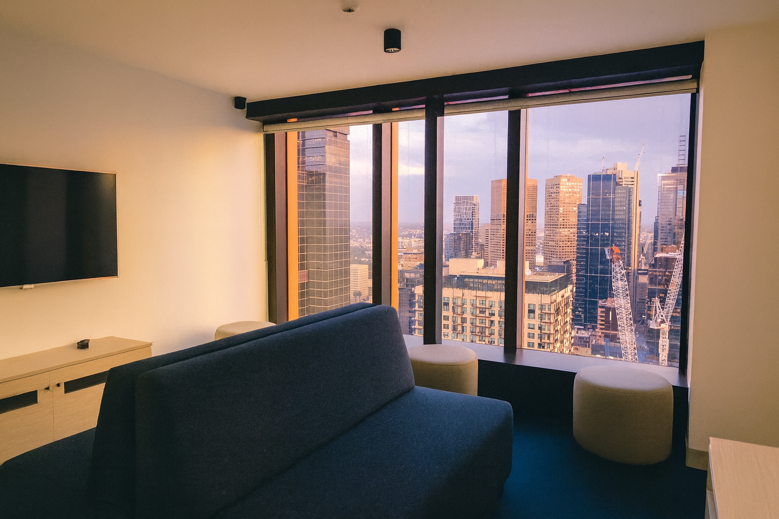 A stylish couch set against a softly decorated room, featuring warm lighting and minimalistic decor