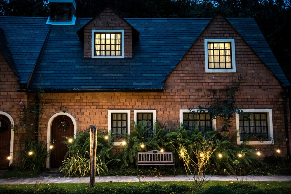 A house with illuminated lights adorning the front porch, creating a warm and inviting atmosphere